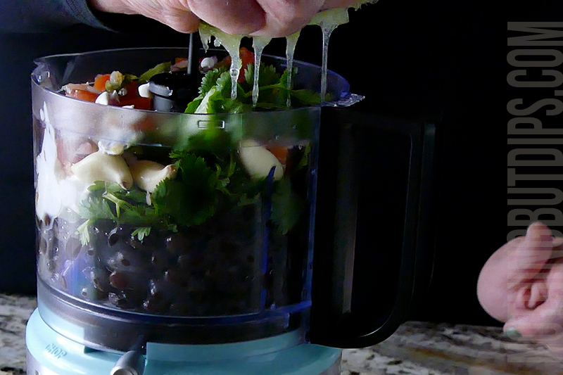 adding a squeeze of lime to the black bean puree mixture in the mini food processor