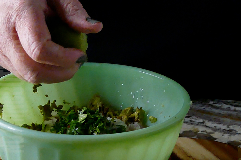 squeezing lime into guacamole