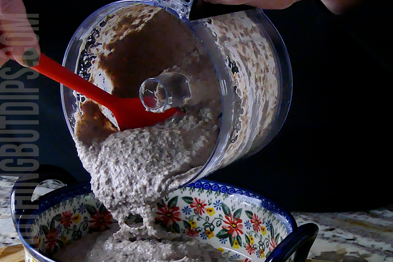 transferring the black bean dip puree from the mini food processor to the serving dish 