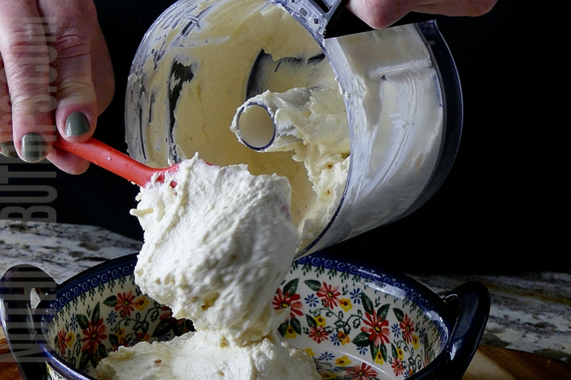 transferring the feta whip from the mini food processor to a serving dish