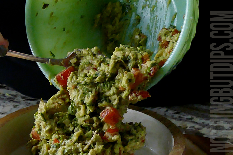 transferring the guacamole to a serving dish 