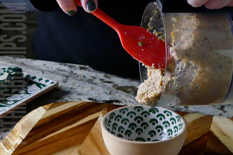 transferring the smoked salami and cheese pate from a mini food processor to a serving dish