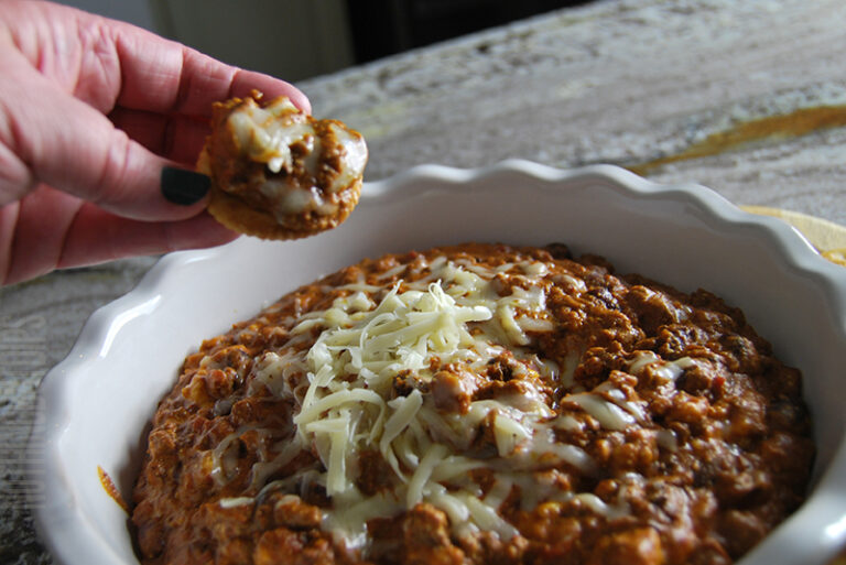 easy crockpot chili cheese dip served on a cracker