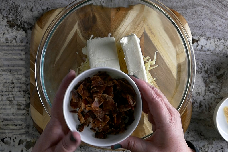 adding bacon to a bowl to make a classic cheese ball