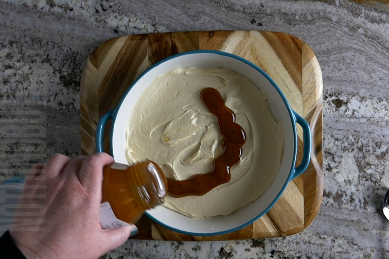 adding caramel topping to the top of the salted caramel dip