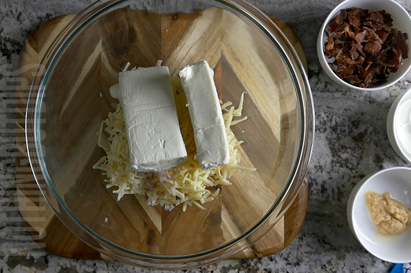 adding cheddar cheese and cream cheese to a bowl to make a classic cheese ball