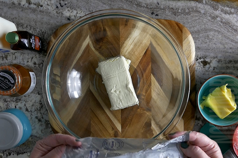 adding cream cheese to the mixing bowl