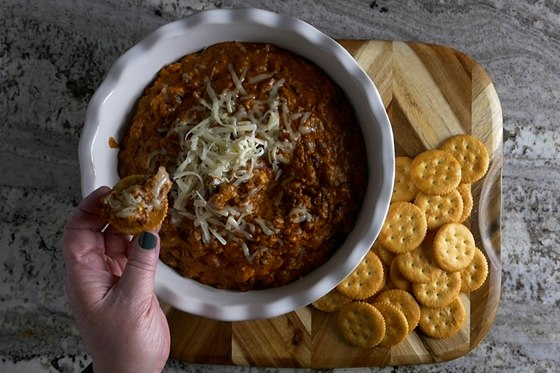 easy crockpot chili cheese dip served on a cracker