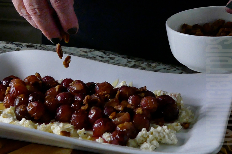 sprinkling toasted pecans on top of roasted grapes on top of Boursin cheese to make a delicious appetizer