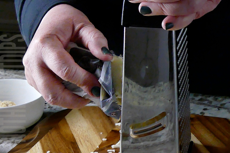 grating the cheddar cheese to make a classic cheese ball
