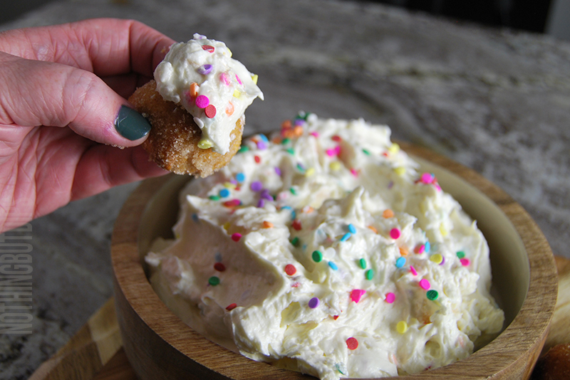 sweet and creamy birthday cake dip being served on a donut hole