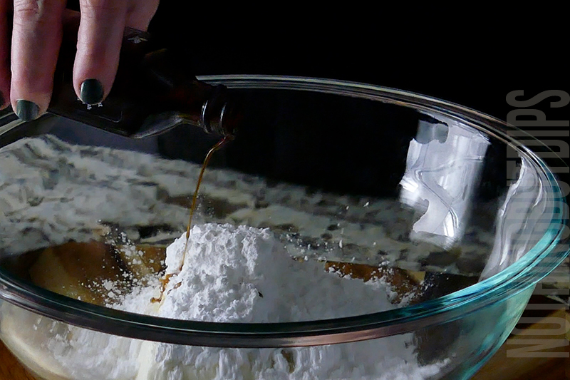 adding vanilla to a mixing bowl to make birthday cake dip