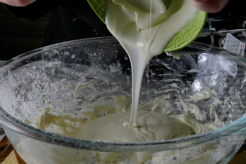 adding the melted white chocolate to the mixture to create birthday cake dip