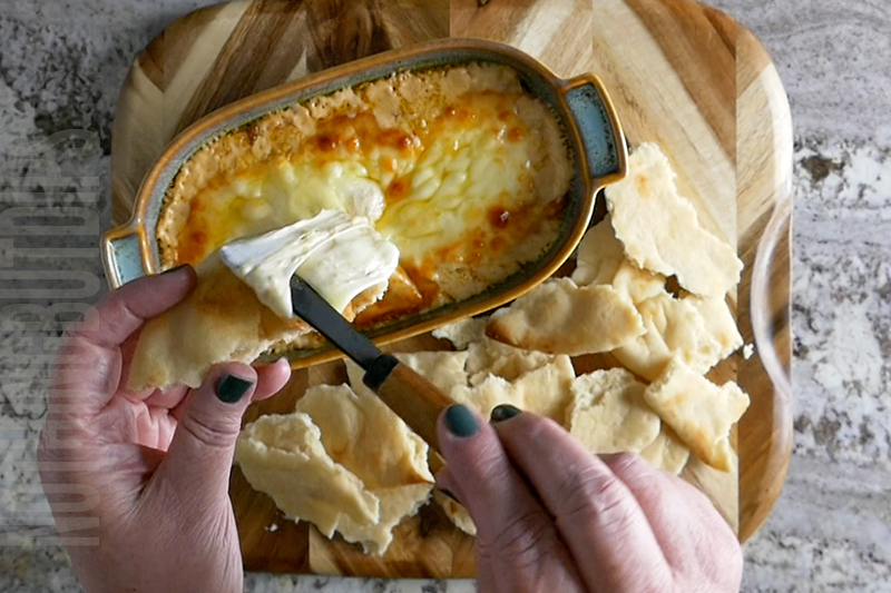 easy baked artichoke dip with melty provolone cheese served on pita