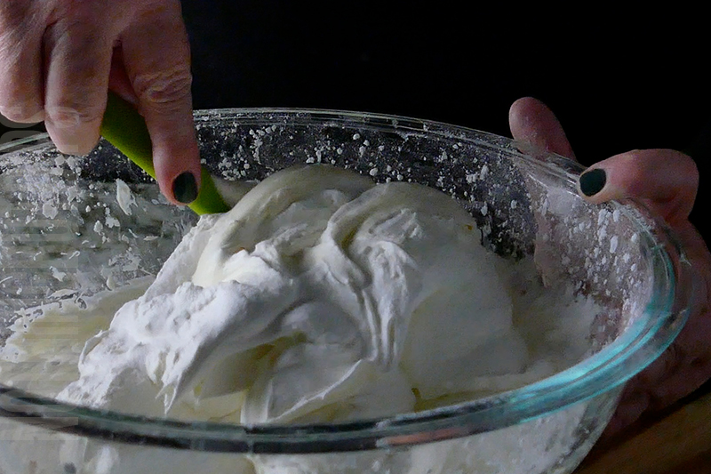 folding whipped cream into the creamy mixture to create birthday cake dip