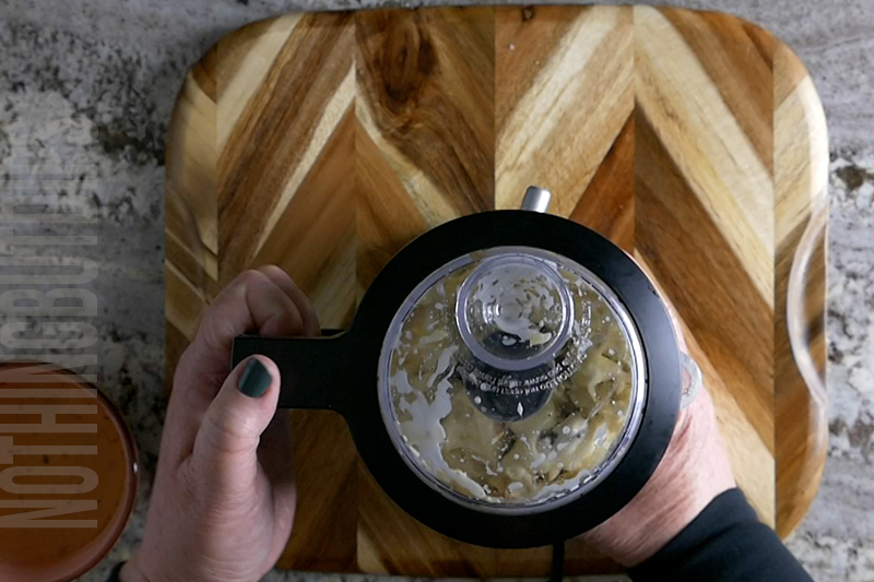 processor ingredients in a mini food processor to make baked artichoke dip