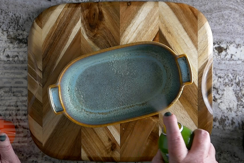 preparing a small baking dish with cooking spray before adding mix for baked artichoke dip