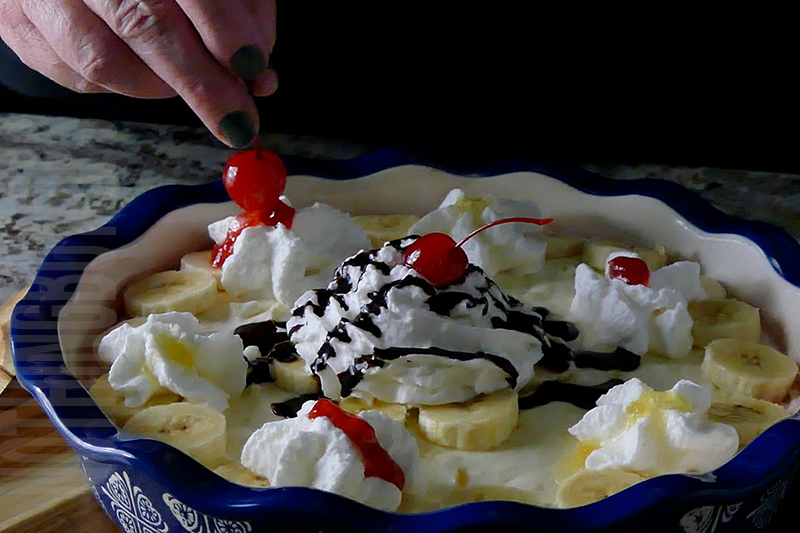 adding cherries on top of the banana split dip