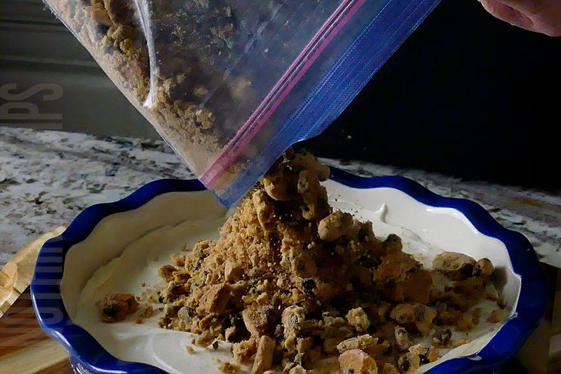 topping the cookies and milk dip with crushed cookies