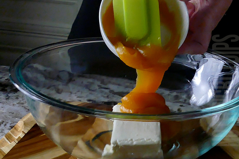 adding passion fruit curd to the bowl for tropical fruit dip dessert