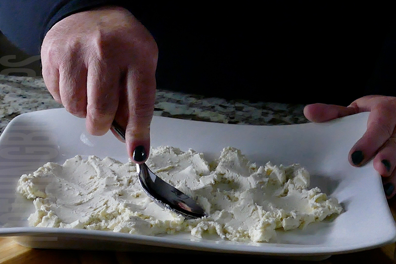 spreading the boursin cheese onto a platter