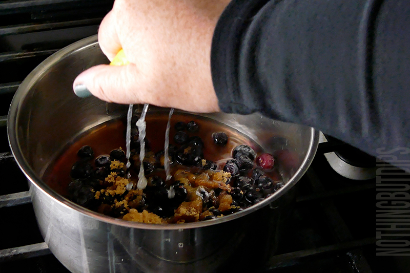 adding lemon juice to a sauce pan to make blueberry compote