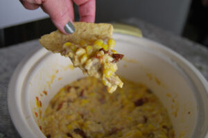 crockpot corn bacon and cheese dip served on a tortilla chip