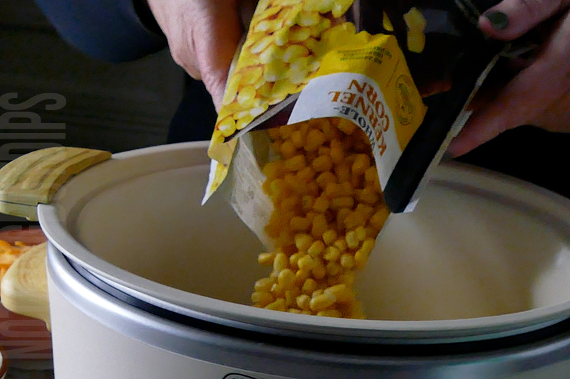 adding sweet corn to the crockpot for cheesy corn and bacon