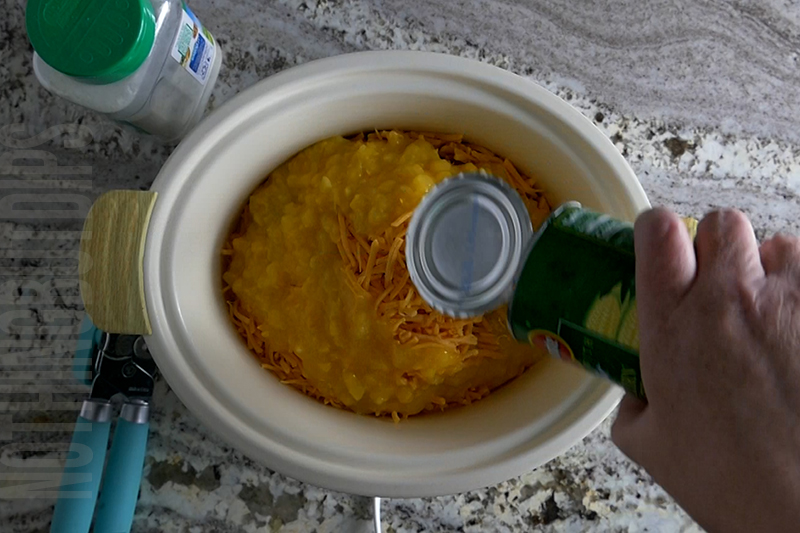 adding cream corn to the crockpot for cheesy corn and bacon