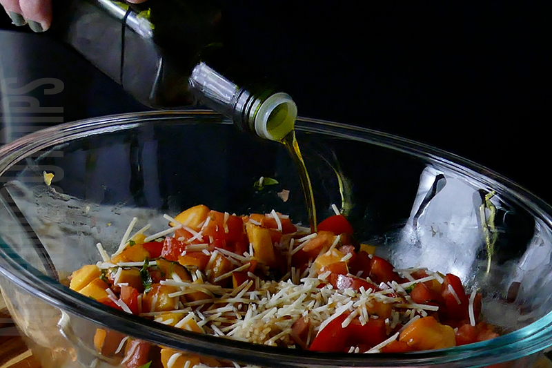 adding olive oil to the peach and tomato bruschetta