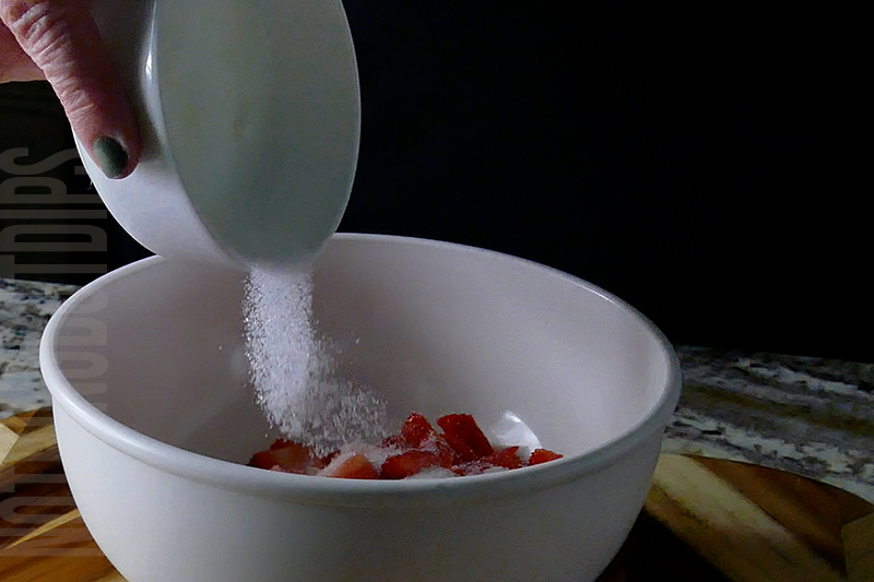 adding sugar to the strawberries