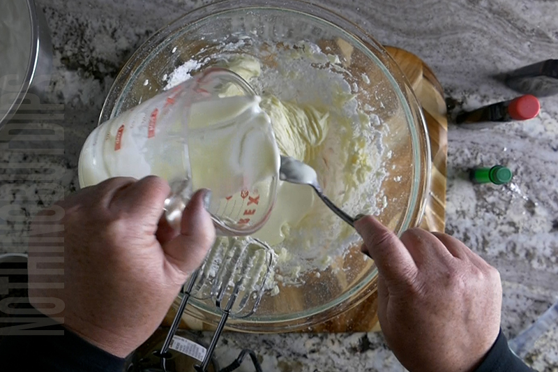 adding melted white chocolate to the bowl to make mint chocolate chip dip
