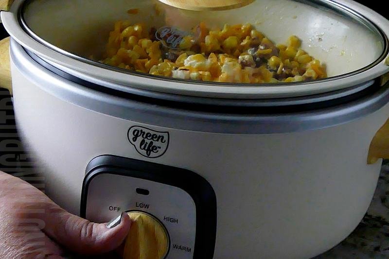 setting the crockpot to low for heating cheesy corn and bacon dip