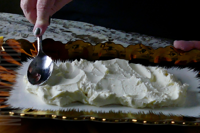 spreading cream cheese on a serving platter