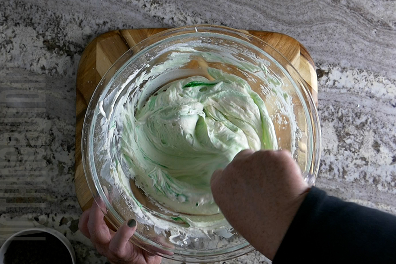 stirring the green food coloring into the mint chocolate chip dip