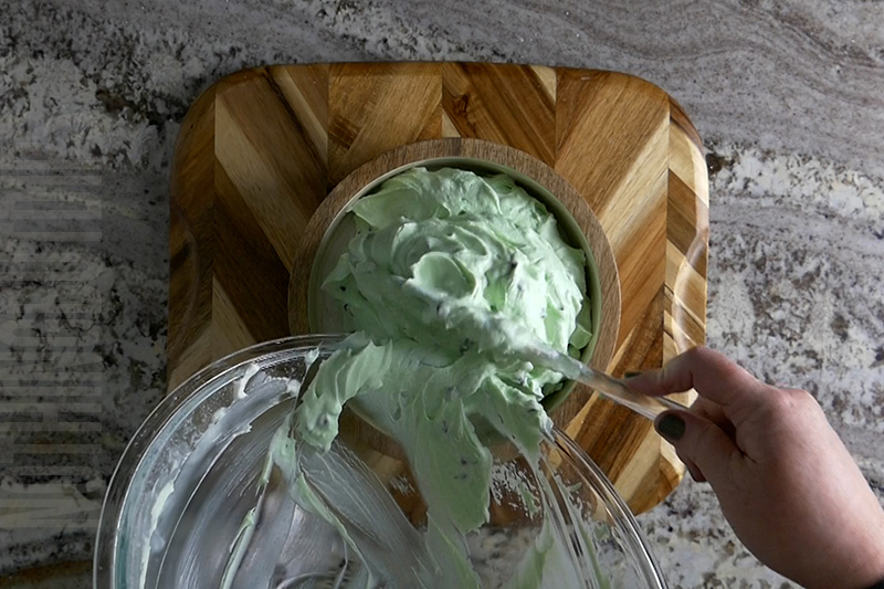 transferring the mint chocolate chip dip from the bowl to a serving dish
