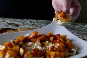 Easy Burrata with peaches appetizer served on a cracker