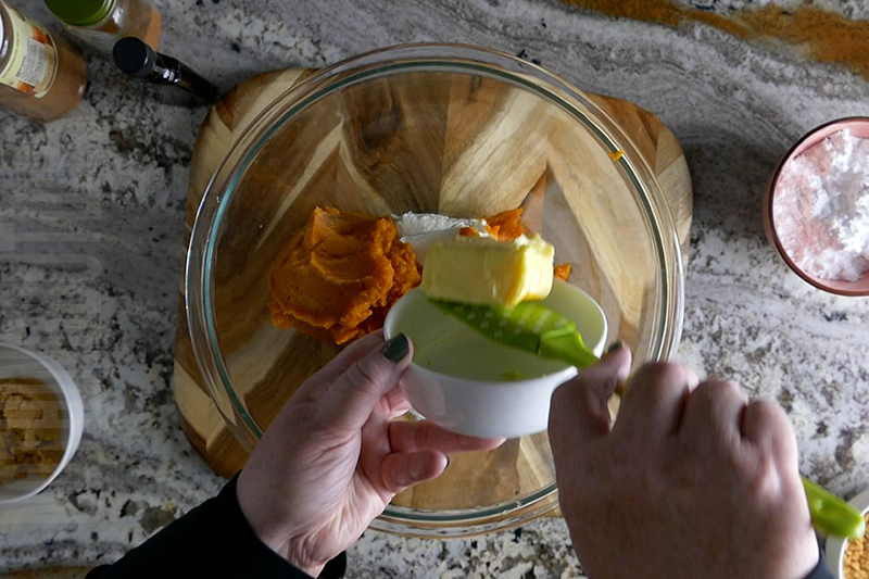 adding butter to the ingredients to make pumpkin cheesecake dip