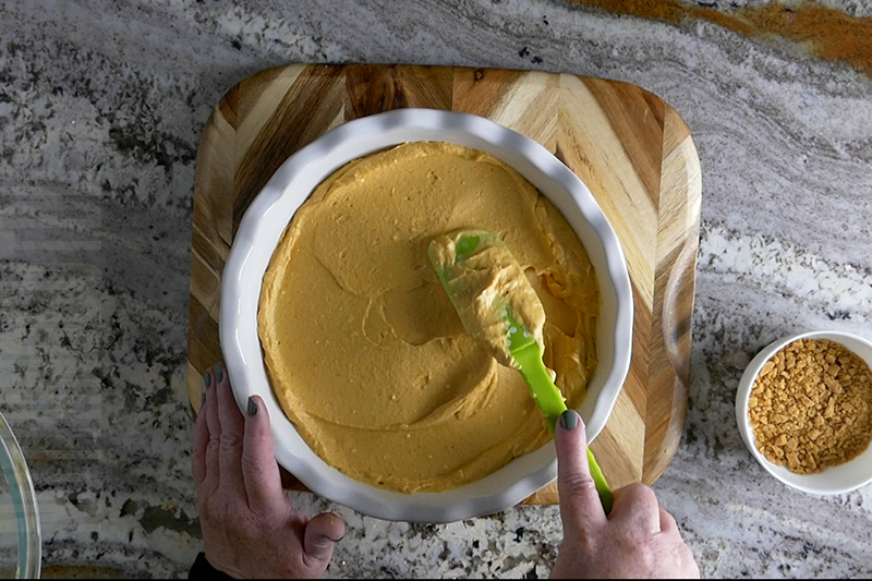 spreading the pumpkin cheesecake mixture into a serving dish