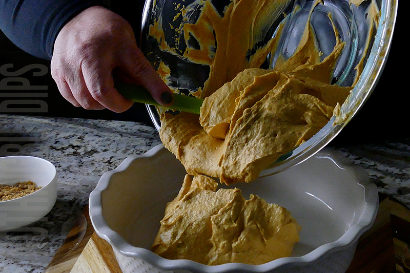 transferring the pumpkin cheesecake dip mixture into a serving dish